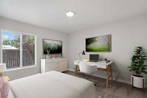 a bedroom with a bed and a desk with a laptop