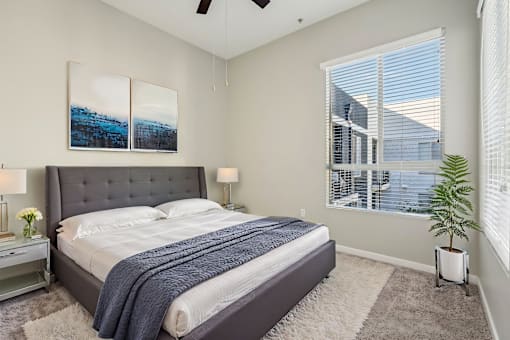 A bedroom with a large bed and a ceiling fan.
