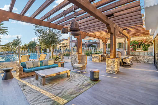 A wooden patio with a blue couch and a table.