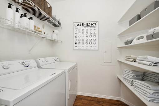 a laundry room with a washer and dryer and a calendar on the wall