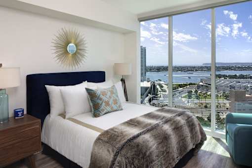 A bedroom with a large bed and a view of the city.