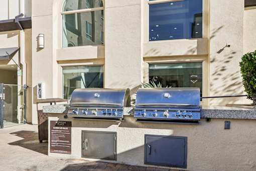 Two grills are outside a building.