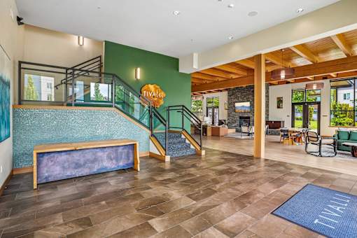A room with a staircase and a blue rug.