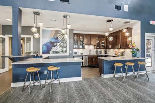 A kitchen with a blue counter and bar stools.