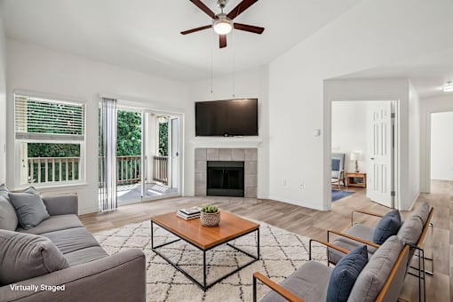 A living room with a grey couch, a coffee table, and a television.