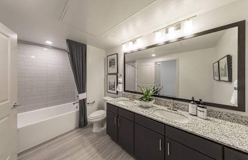 a bathroom with a large mirror and a toilet and a shower