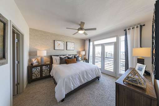 a bedroom with a large bed and a ceiling fan