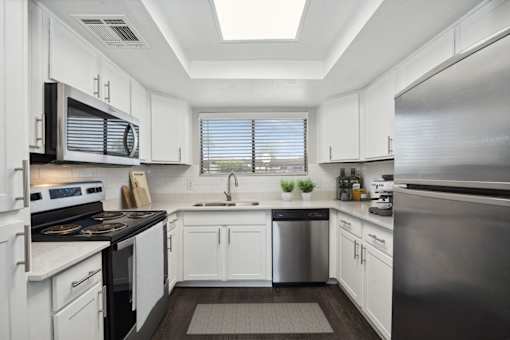 a kitchen with white cabinets and stainless steel appliances