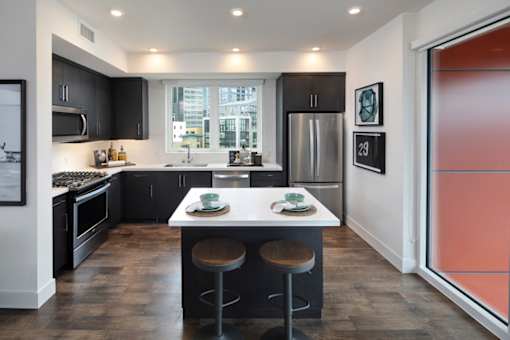 A modern kitchen with a large island and stools.