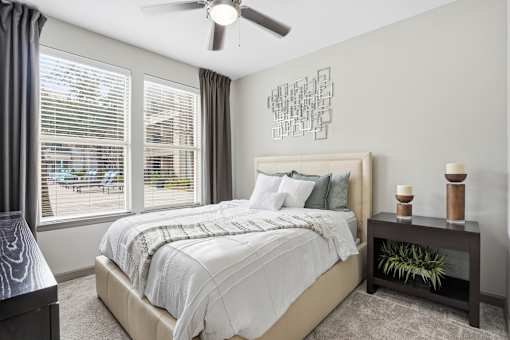 A bedroom with a large bed and a ceiling fan.