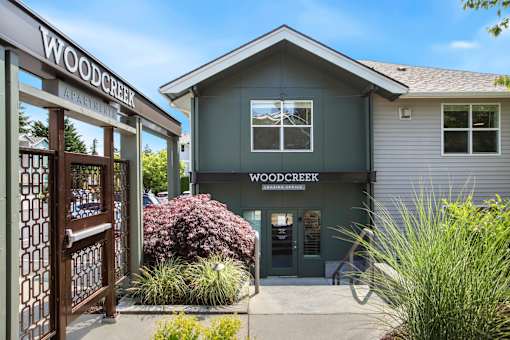 The front of the Woodcreek Apartments building with a clear blue sky in the background.