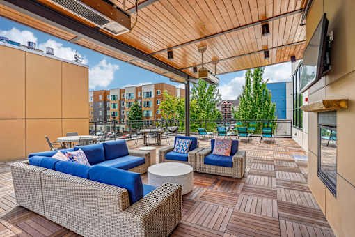 A patio with blue couches and a wooden floor.