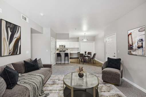 the living room and dining room of an apartment with couches and a table