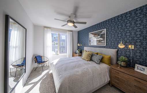 a bedroom with blue wallpaper and a white bed