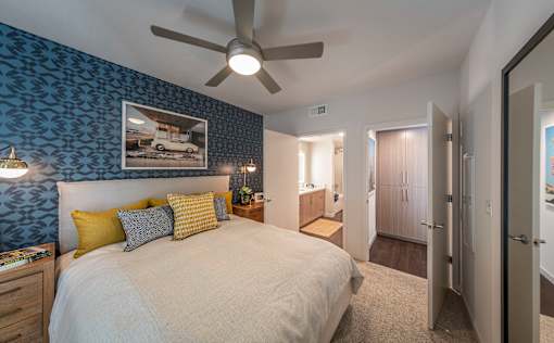 a bedroom with a large bed and a ceiling fan