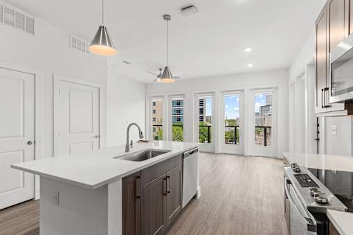 A modern kitchen with white countertops and dark brown cabinets.