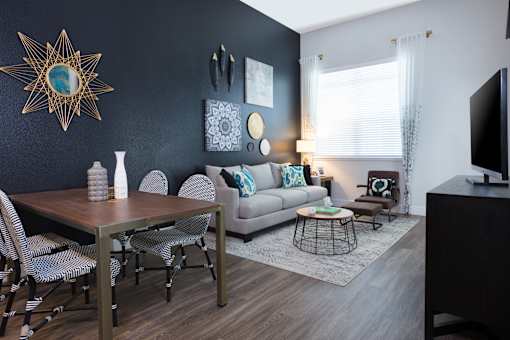 a living and dining room area with a couch table and chairs and a tv on a stand