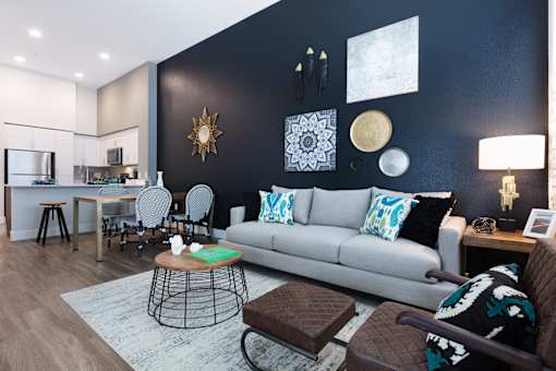 a living room with a gray couch and blue and white pillows