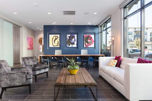 a living room with a blue accent wall and a wooden coffee table with a potted plant