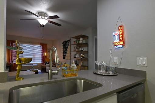A kitchen with a Happy Hour Club neon sign.