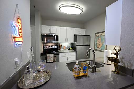 A kitchen with a neon sign hanging above the counter.