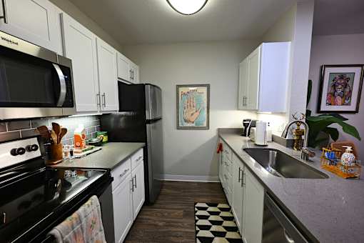 A kitchen with black appliances and white cabinets.