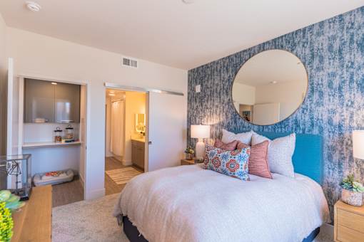 a bedroom with a large bed and a mirror on the wall