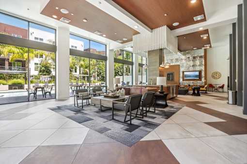 a large lobby with a table and chairs and large windows