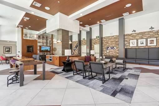 a large lobby with tables and chairs and a reception area