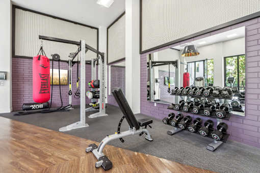 a home gym with weights and a red punching bag