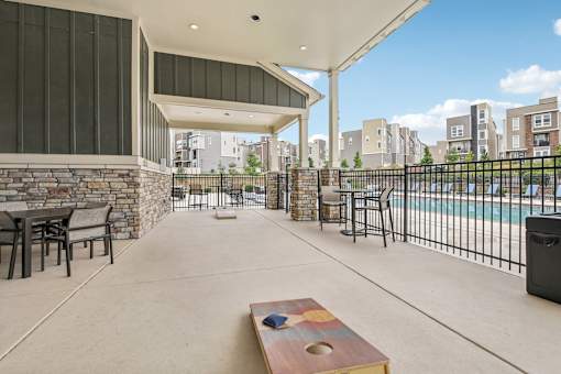 the outlook of a patio with tables and chairs and a pool