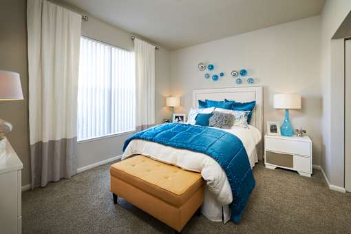 a bedroom with a large bed and blue and white bedding