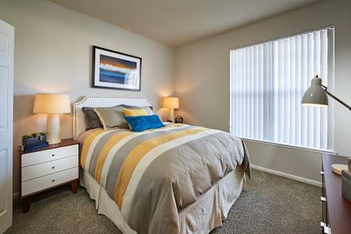 a bedroom with a bed and two windows