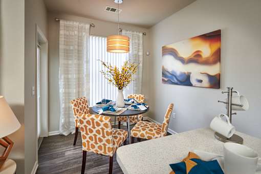 a dining room with a table and chairs and a painting on the wall