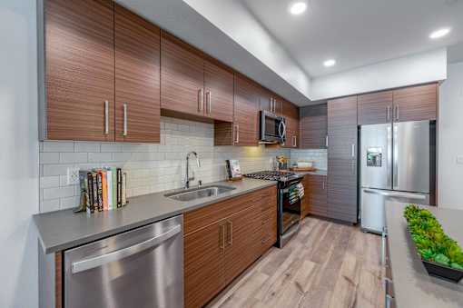 A modern kitchen with wooden cabinets and stainless steel appliances.