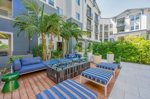 A patio with blue furniture around a fire pit
