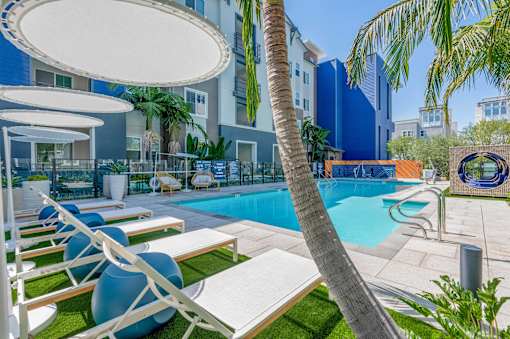 A pool area with lounge chairs and umbrellas.