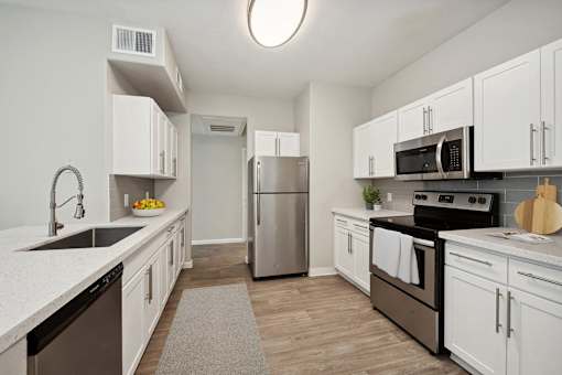 a kitchen with white cabinets and stainless steel appliances
