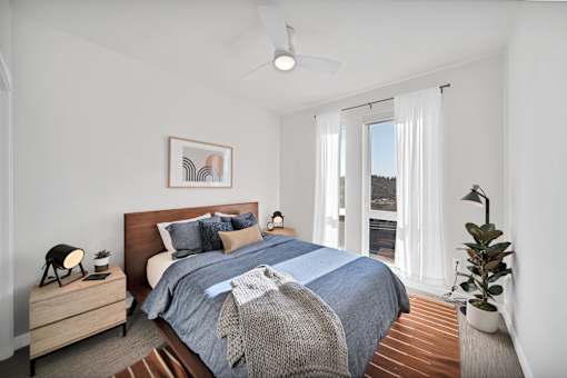 a bedroom with a bed and a large window