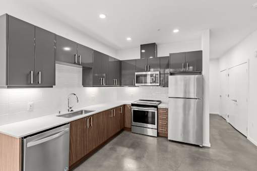 A modern kitchen with stainless steel appliances and wooden cabinets.