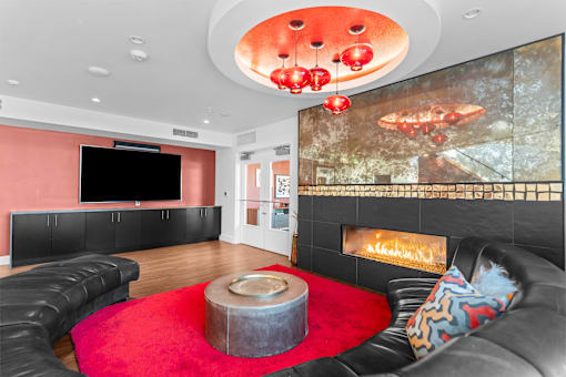 A modern living room with a fireplace and a large screen tv.