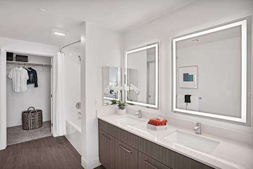 a bathroom with two sinks and two mirrors
