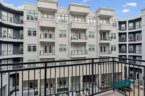 Apartment building with balconies and a pool.
