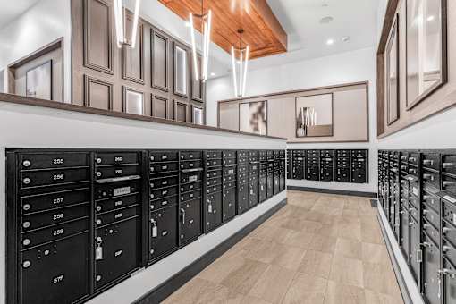 A long hallway with a series of mailboxes on the wall.