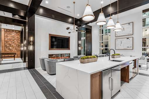 A modern kitchen with a white countertop and stainless steel appliances.