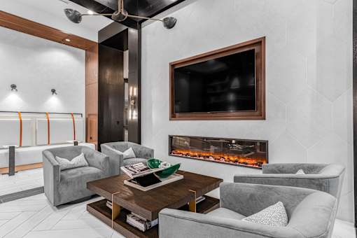A modern living room with a fireplace and a flat screen TV mounted on the wall.