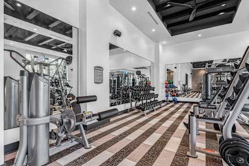 A gym with a variety of equipment including weights and machines.