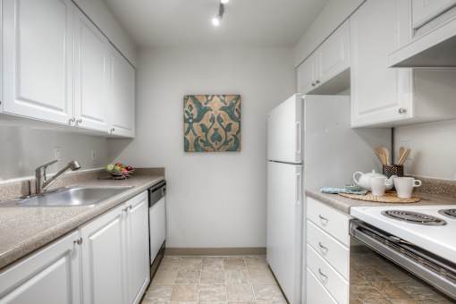 A kitchen with white cabinets and a tile backsplash.