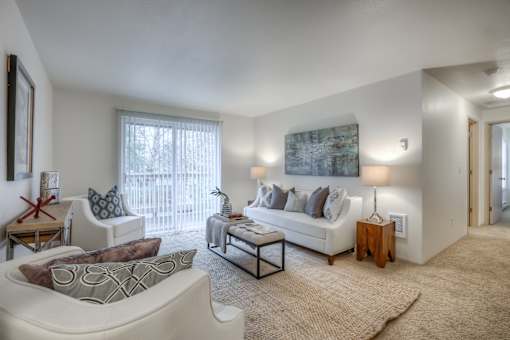 A living room with a white couch, a coffee table, and a painting on the wall.