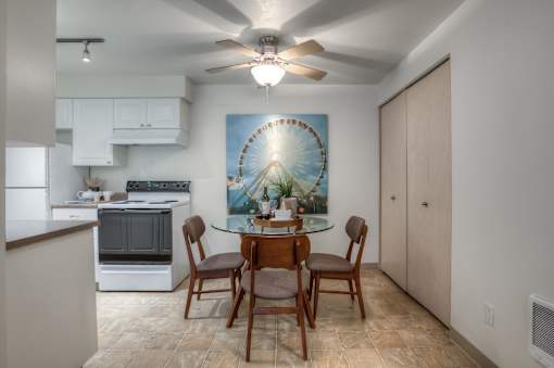 A kitchen with a dining table and chairs.